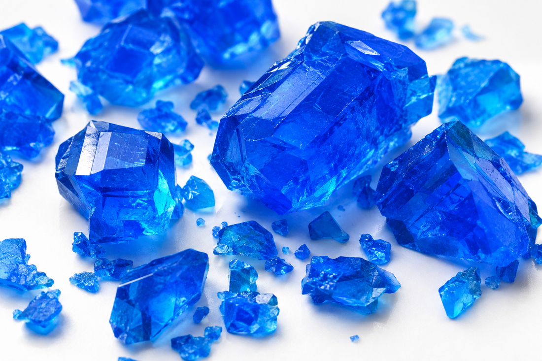 Cristalli blu di solfato di rame pentaidrato su fondo bianco